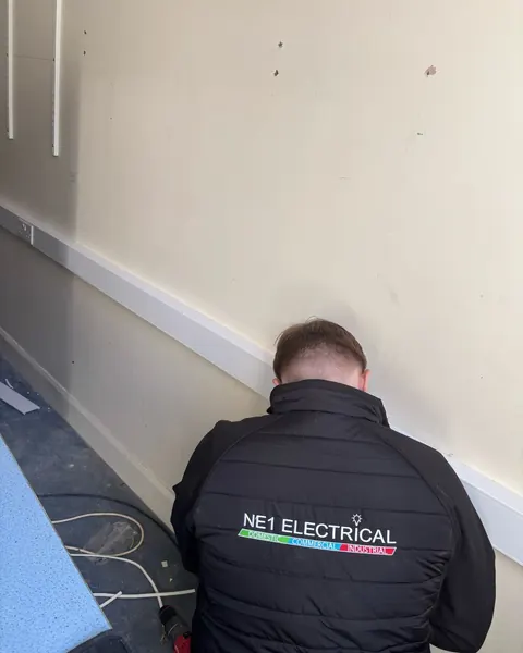 NE1 Electrical electrician installing dado trunking and sockets in a commercial unit