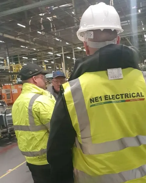 NE1 Electrical electricians in branded hi-vis vests on an industrial site in Sunderland